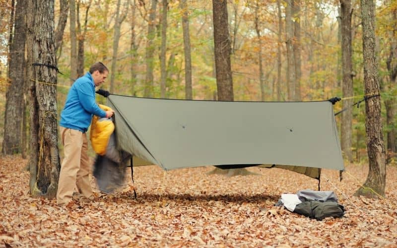 Man putting up hammock tarp