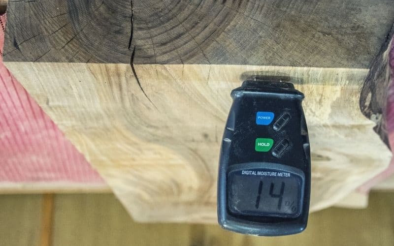 Moisture meter measuring the moisture content of a split log