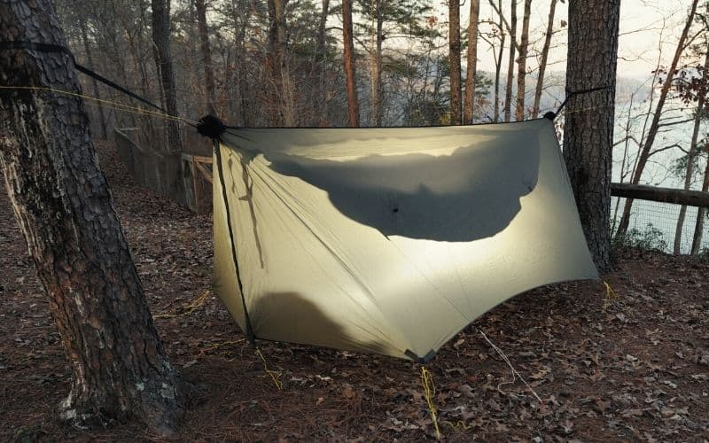 Silhouette of hammock underneath a full rain tarp