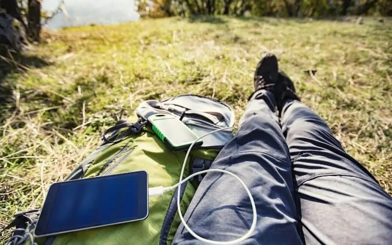 View of campers legs lying down whilst a tablet charges from a portable power pack