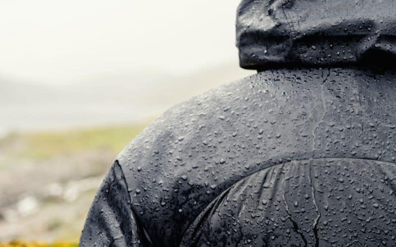 Water beading up on the outside of a black rain jacket