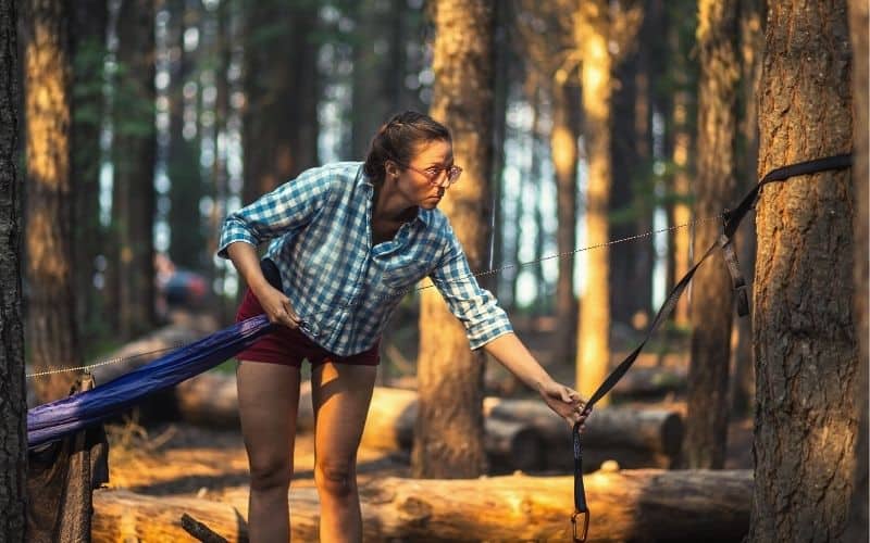 Woman hanging hammock on a tree