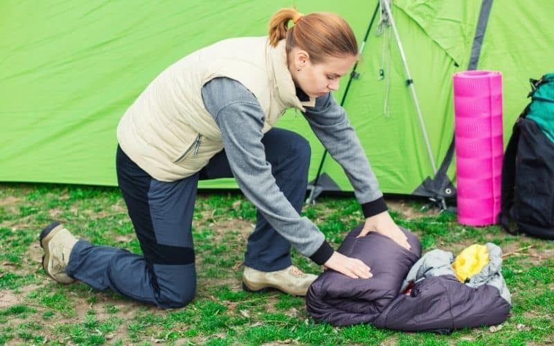 Woman rolling air out of sleeping bag