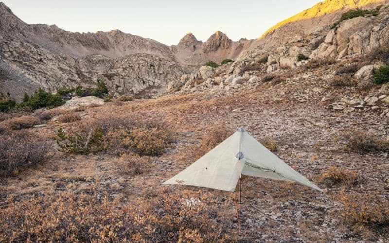 A well pitched tarp in a rocky field