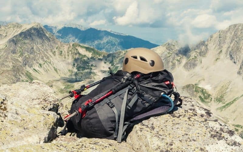 Adjustable trekking poles attached to a backpack