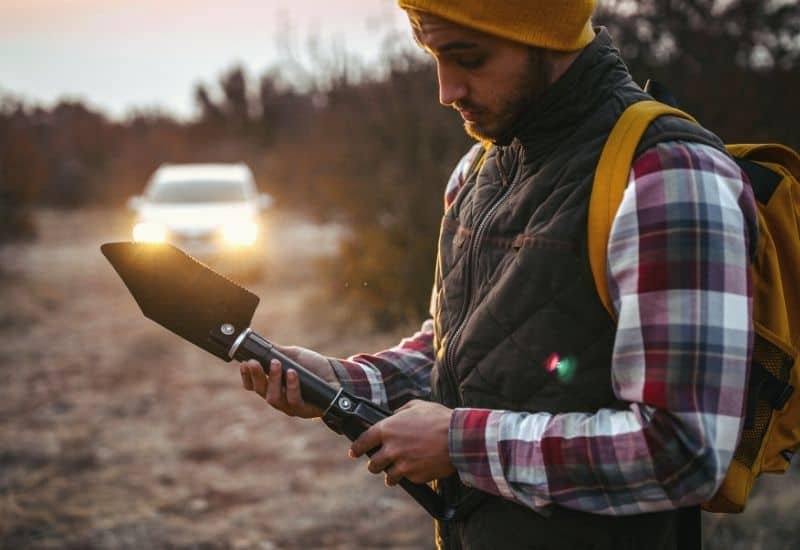 Man holding foldable camping trowel