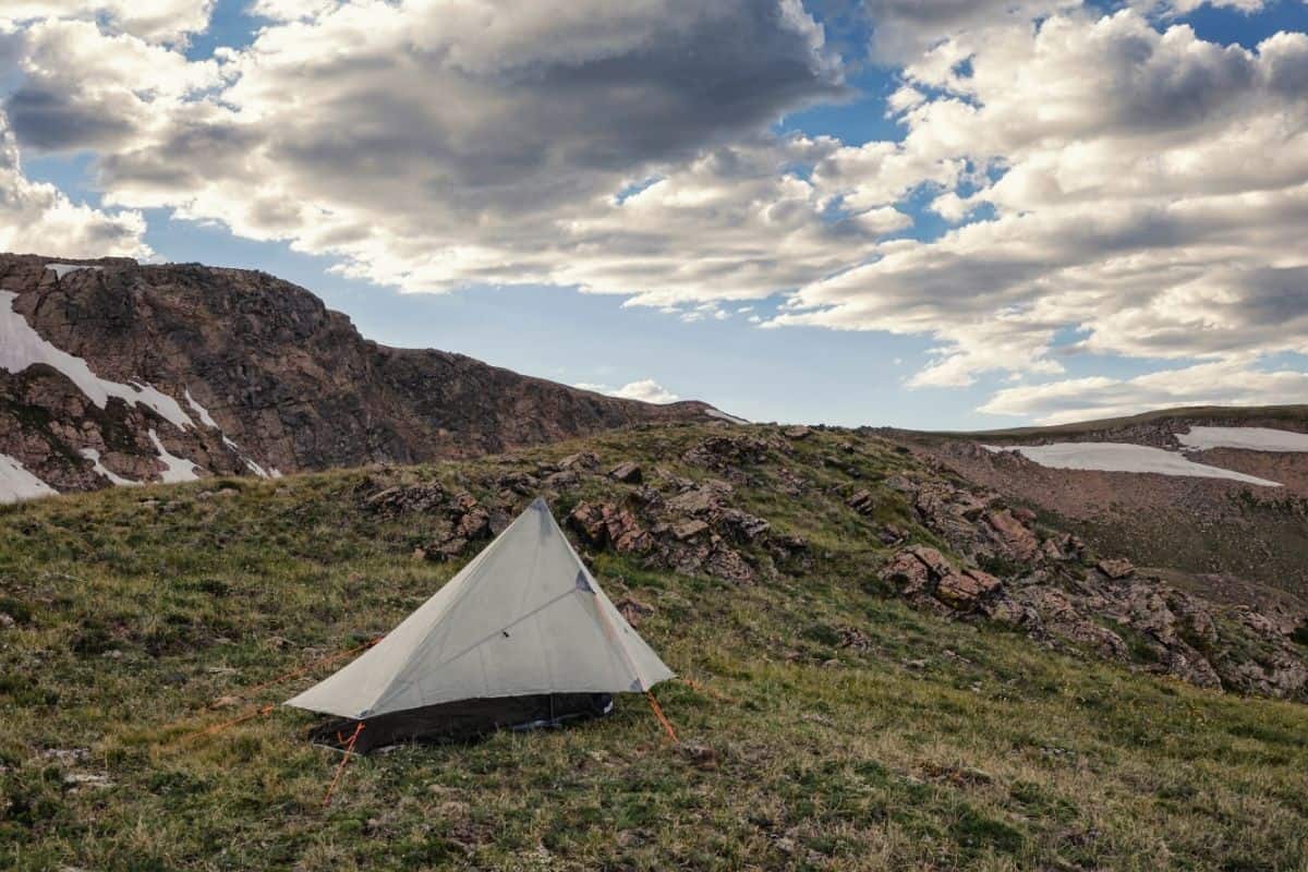 Tent pitched in wilderness with a tarp pitched over it