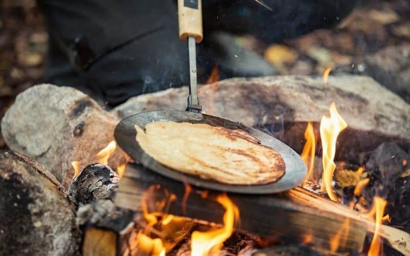 Making pancakes over a campfire