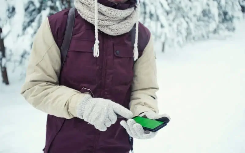Man using his phone to navigate in the snow