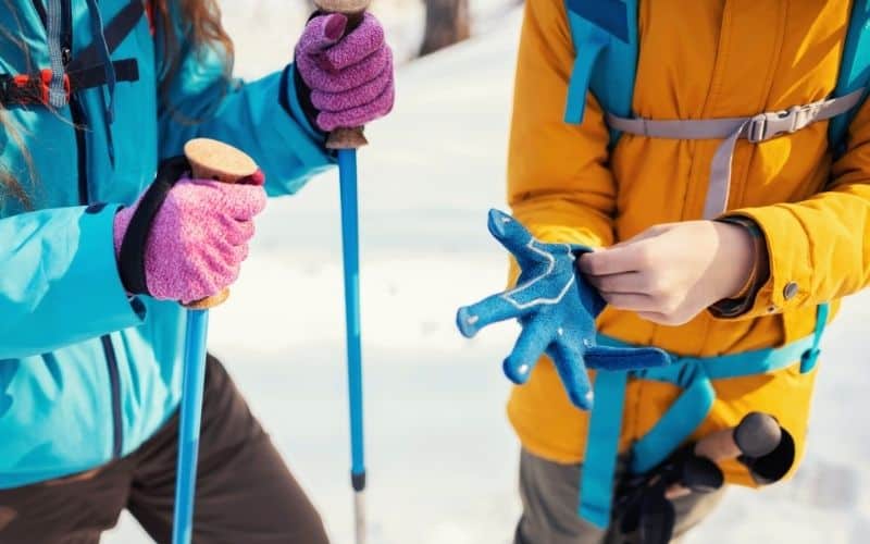 People putting on gloves to hike in the snow