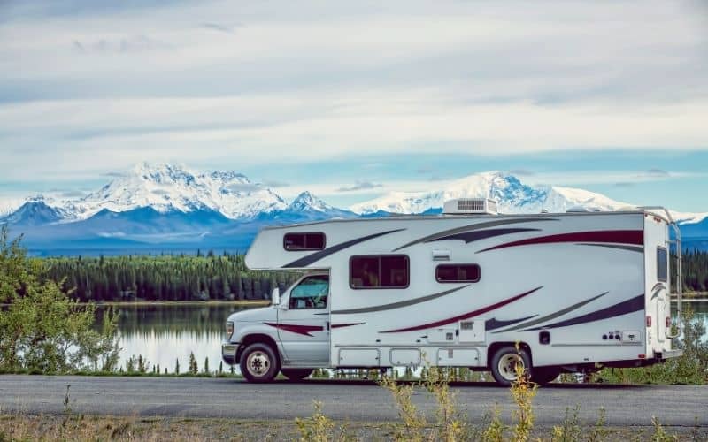 RV boondocking in front of a lake and mountains in Alaska