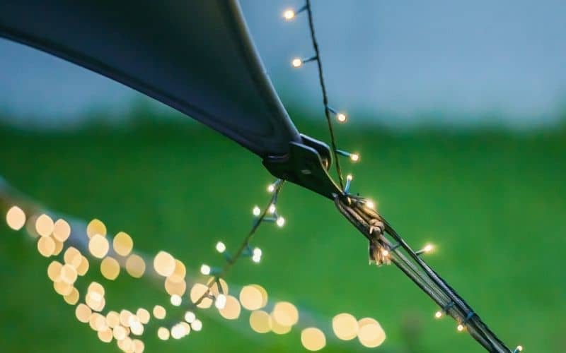 String lights strung around the guylines of a pitched tent