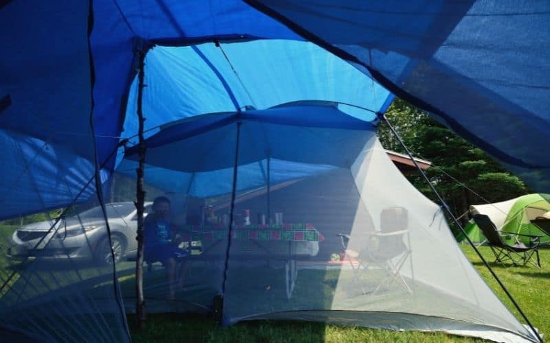 Tarp pitched over a screen tent