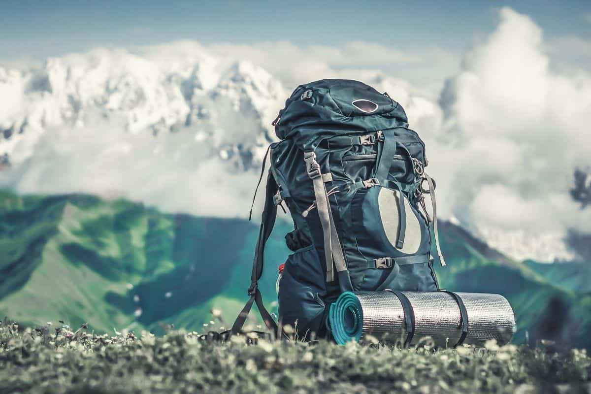 A packed backpack sitting in front of a mountain scene