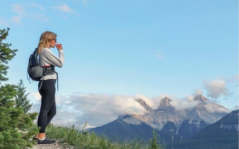 Woman eating apple on a mountain top