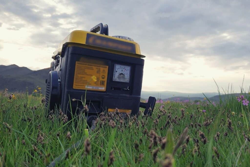 A portable generator sitting in a grassy field of flower