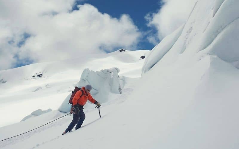 Hiker climbing up snowy slope