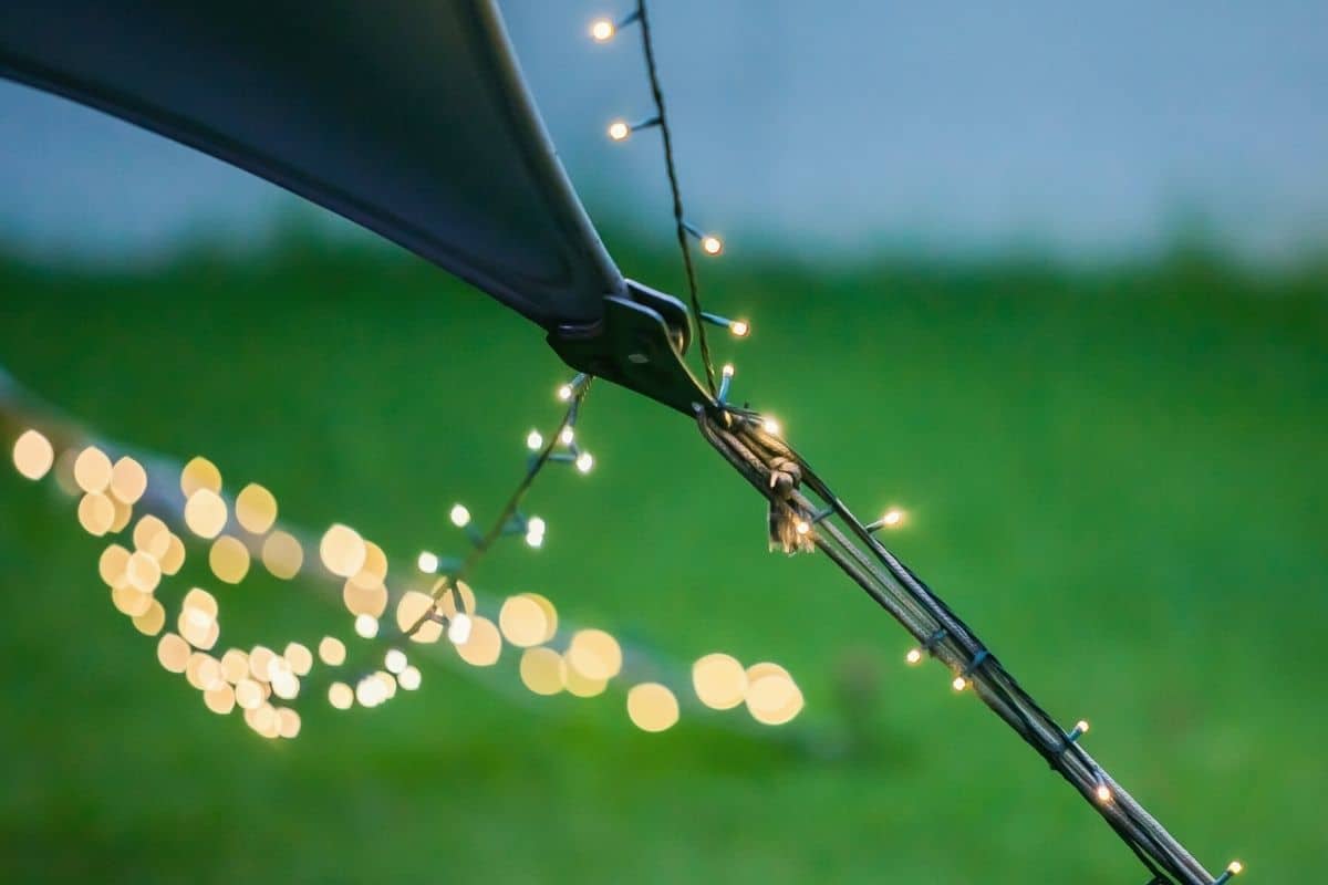 String lights strung around the guylines of a pitched tent