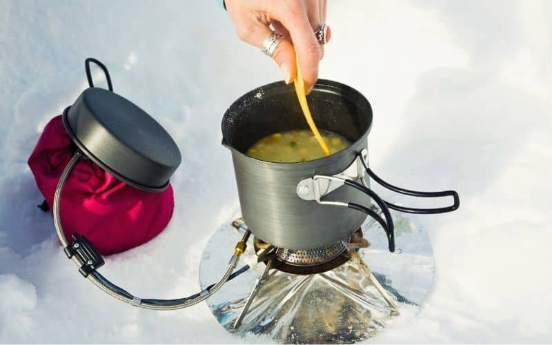 Liquid gas fueling camp stove in the snow