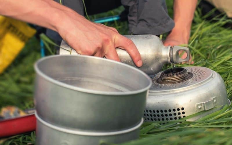 Man filling alcohol stove