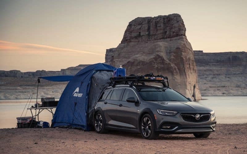 SUV tent with awning out attached to the back of a vehicle