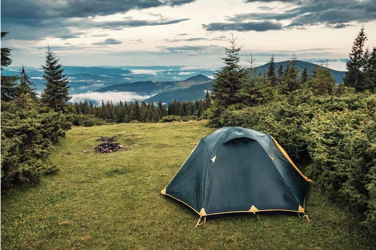 Wet tent pitched under a cloudy sky