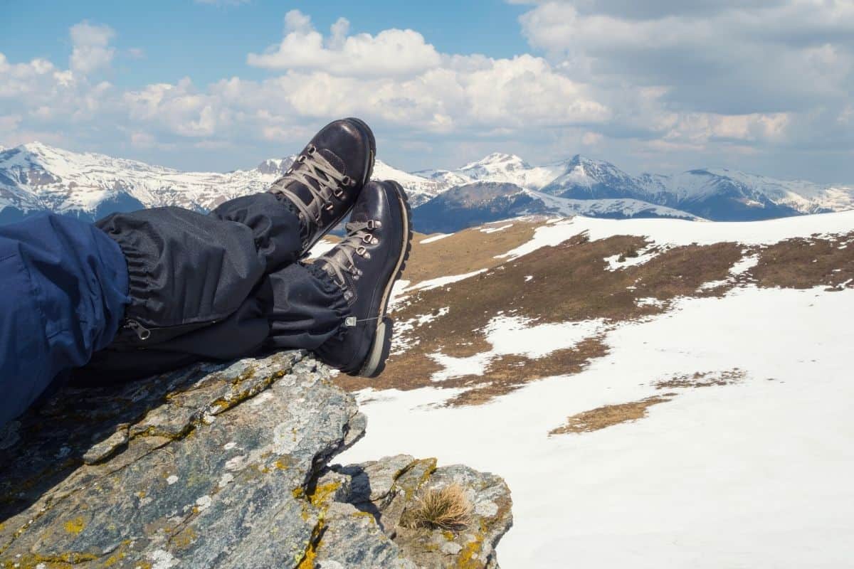 Person with their feet resting on rock wearing hiking boots