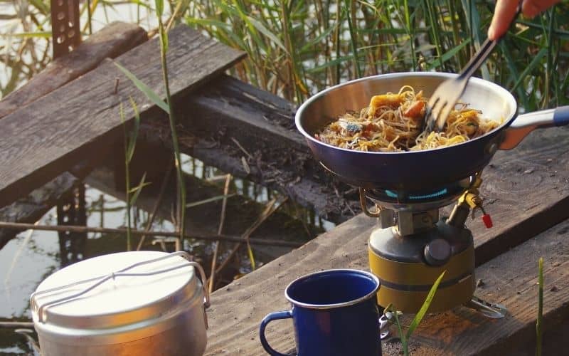 Cooking noodles over a camp stove