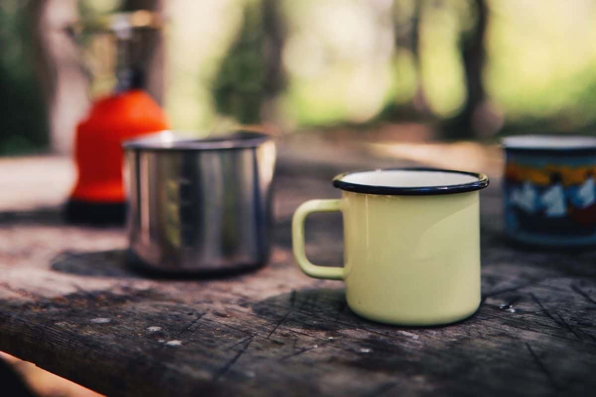 camping coffee mugs sitting on a wooden table