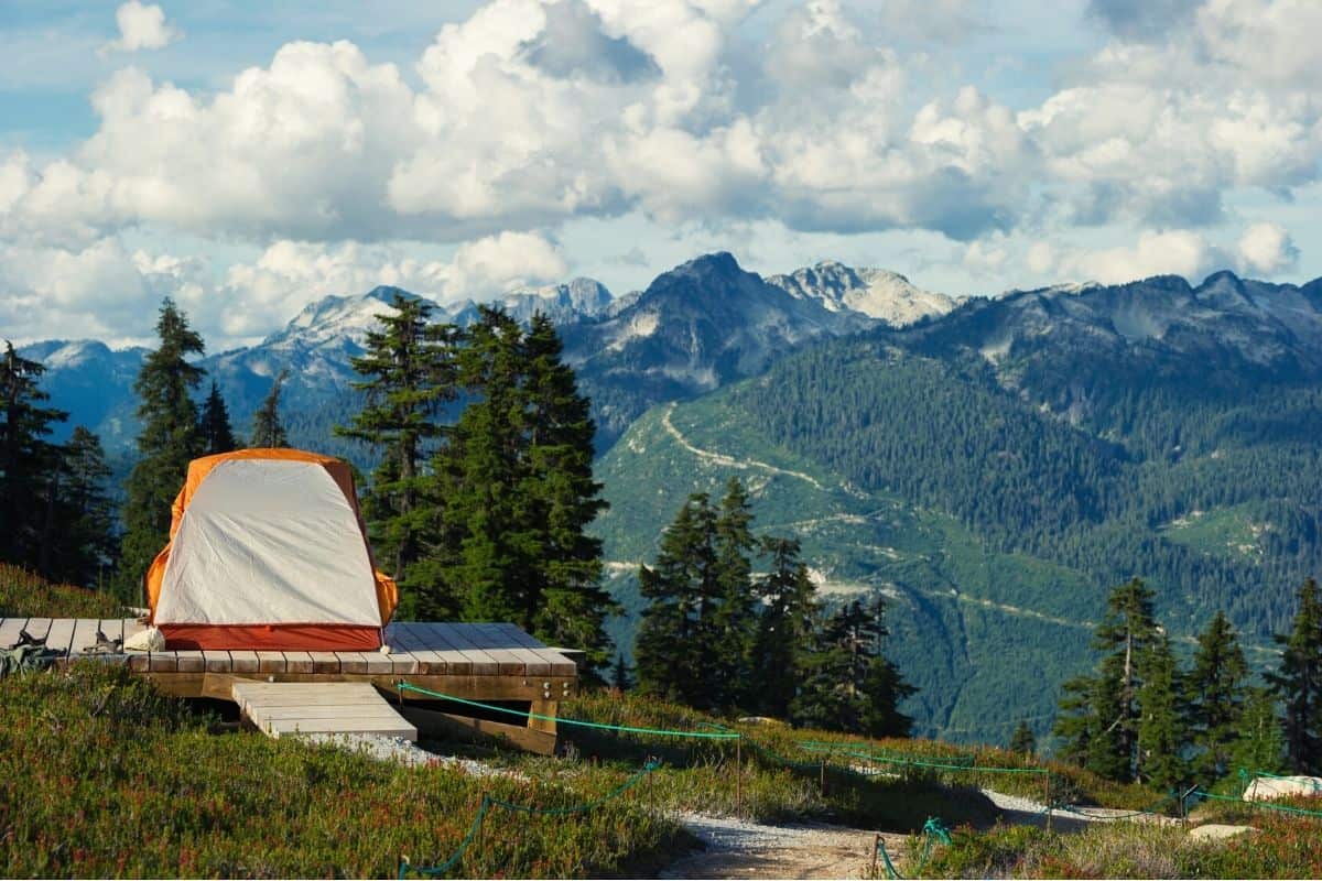 Tall tent pitched in front of mountains