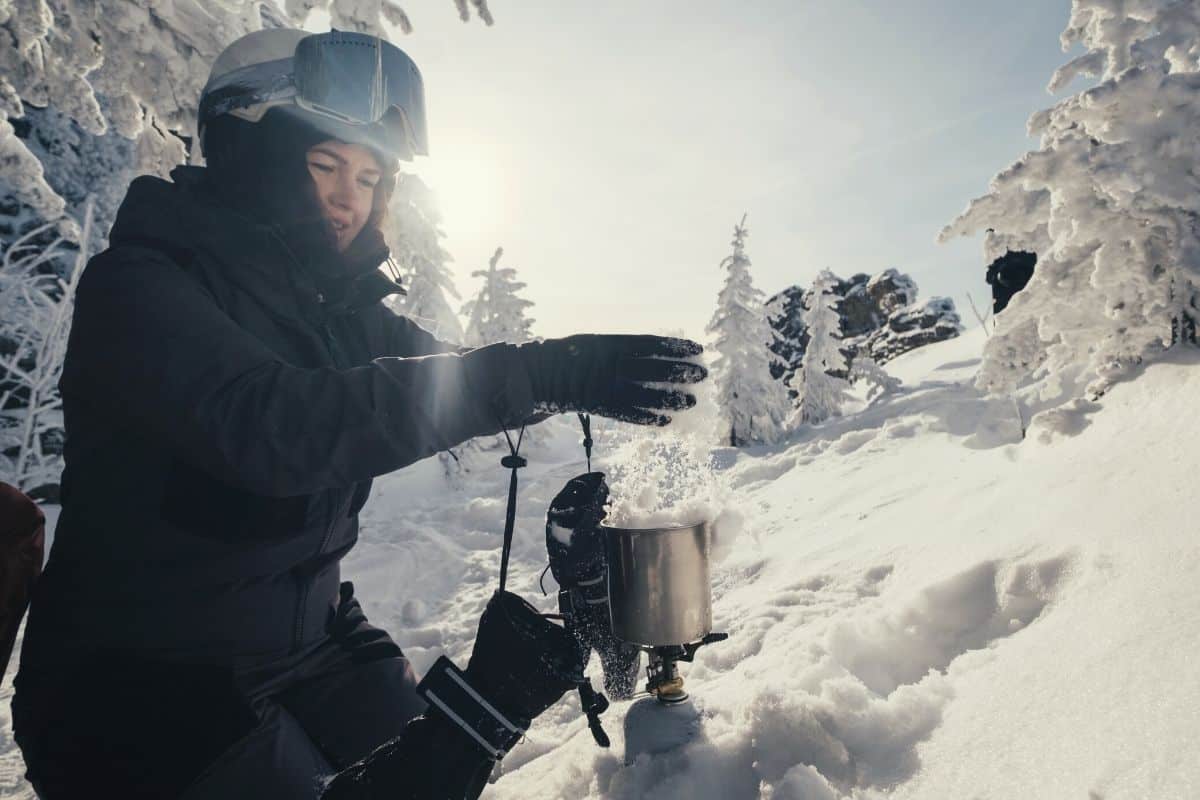 Women melting snow with stove