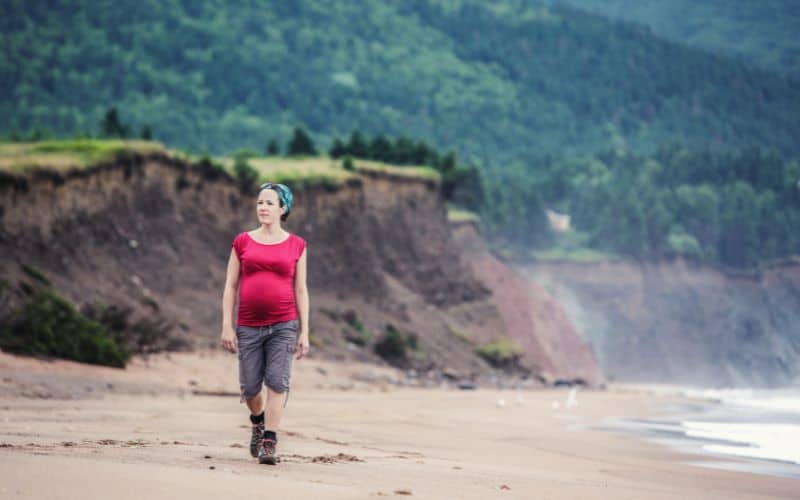 pregnant woman hiking along coastal path