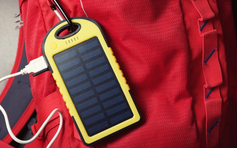 Solar panel charger attached to backpack with carabiner