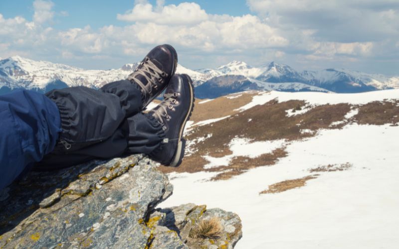 Boots resting on rock in front of snowy landscape