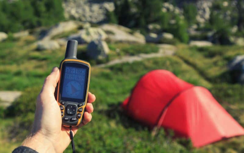 Handheld GPS in front of tent