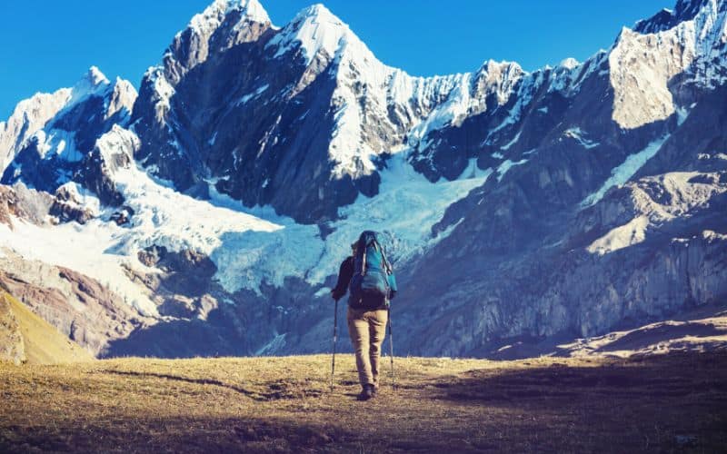 Hiker walking towards mountains