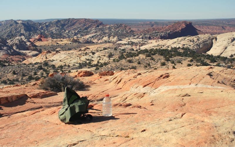 Large fanny pack and water bottle sitting in front of the Grand Staircase-Escalante