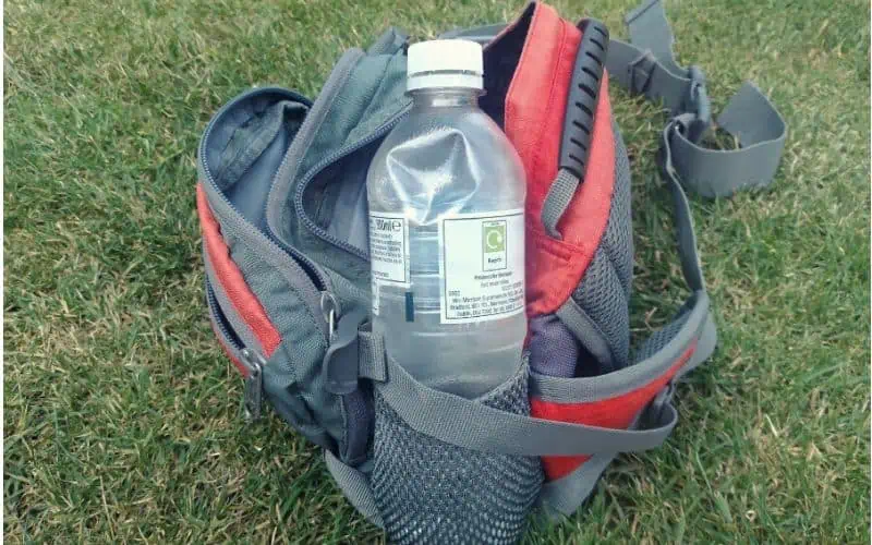 The water bottle holder on the side of a fanny pack