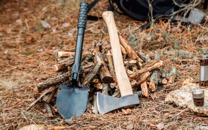 Camping shovel with serrated blade and axe