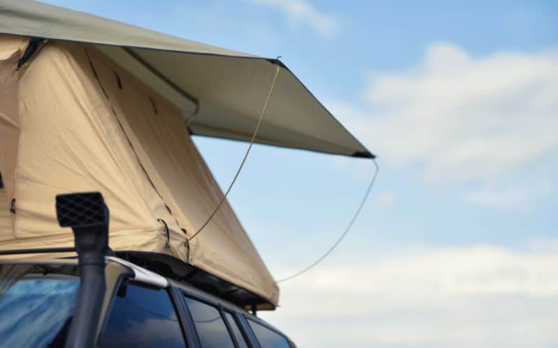 Canvas tent pitched on top of car