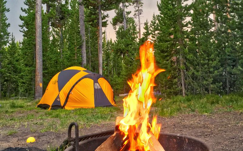 Tent pitched in Yellowstone National Park in front of campfire