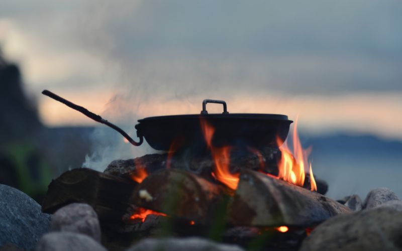 Frying pan sitting over an open fire at dusk