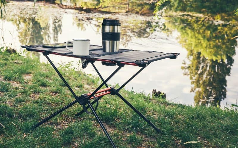 Camping table setup beside a river