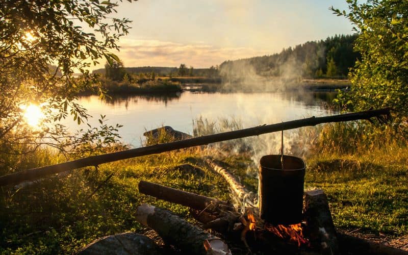 Water boiling over a fire at a campsite