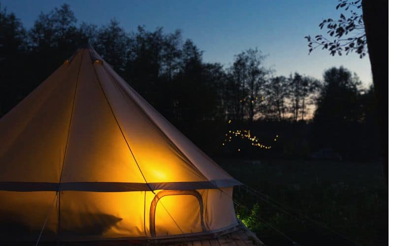 Canvas tent at dusk lit up from inside