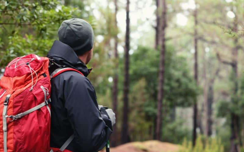 Man wearing hardshell jacket and backpack