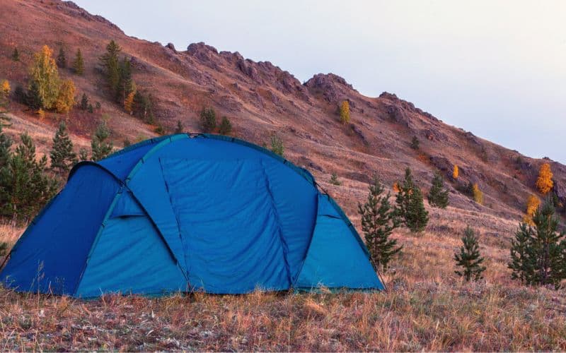 Multi-room tent pitched in a rocky landscape