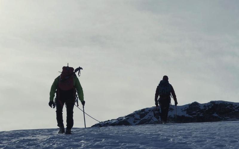 Hikers crossing a glacier with ice axes