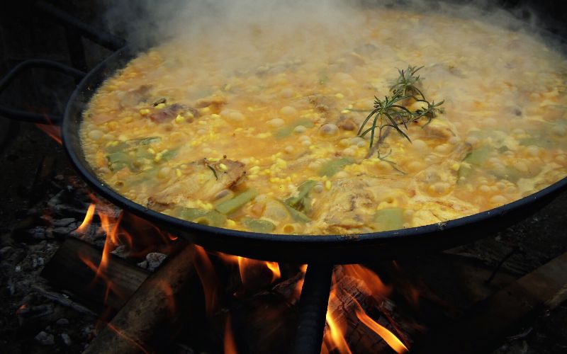 Artichoke paella cooking over campfire