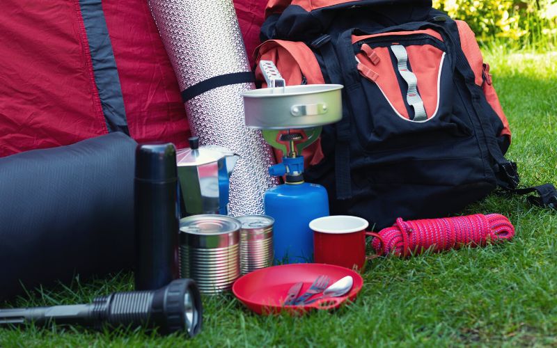 Camping gear including coffee cans outside of tent